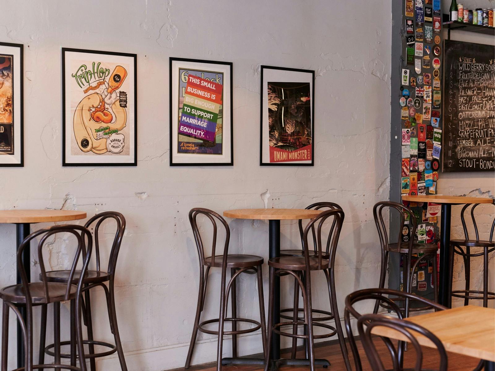Bar tables against wall with posters in frames hanging on the wall
