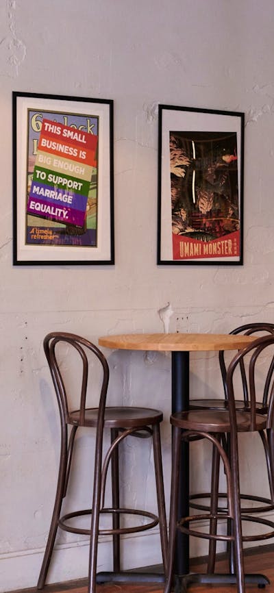 Bar tables against wall with posters in frames hanging on the wall