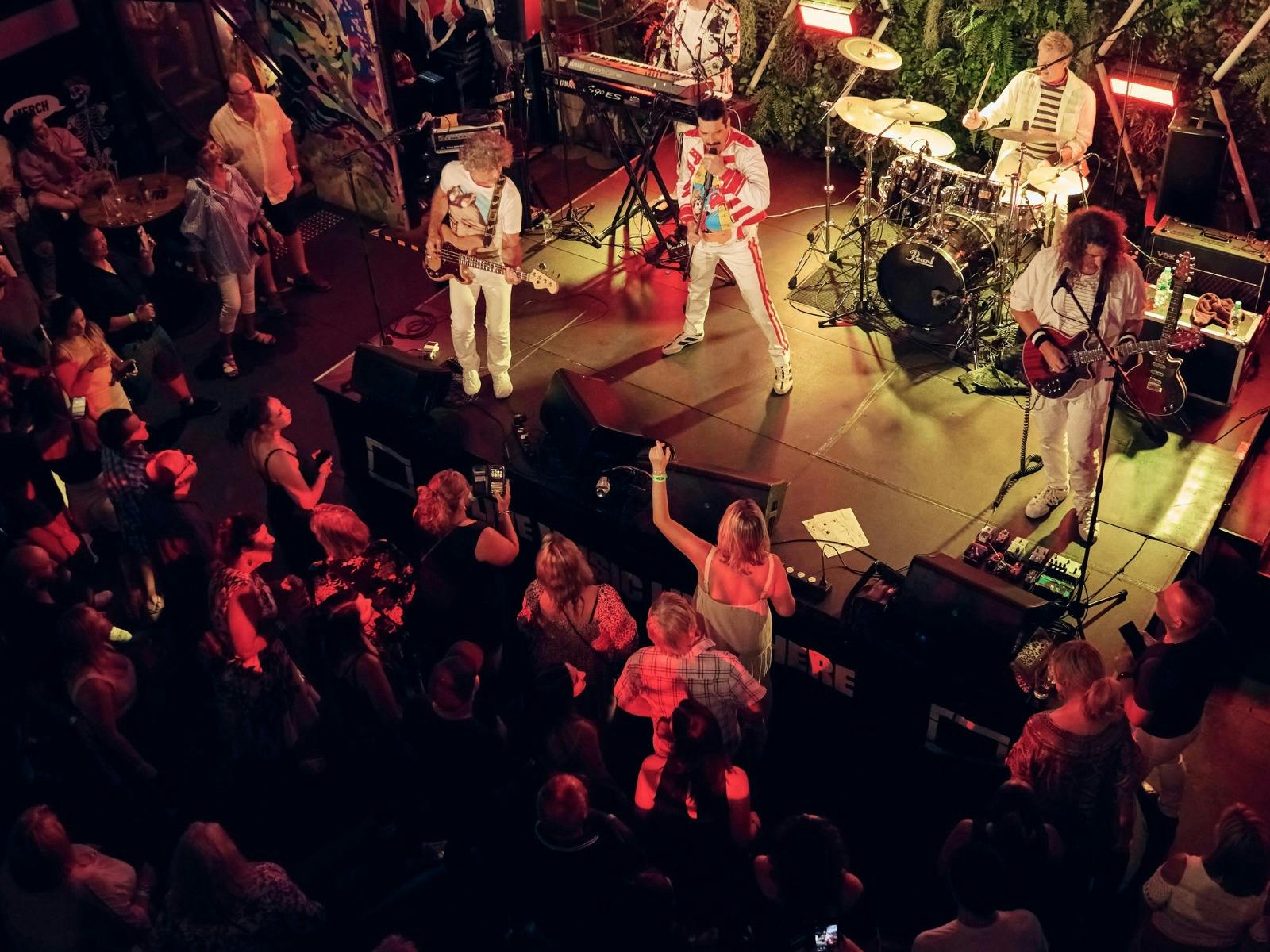 Killer Queen Experience performing to a crowd at The District.