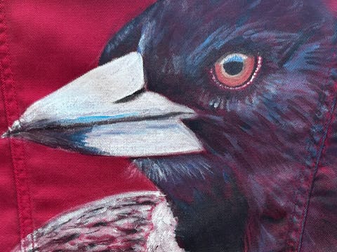 magpie painted on denim jacket