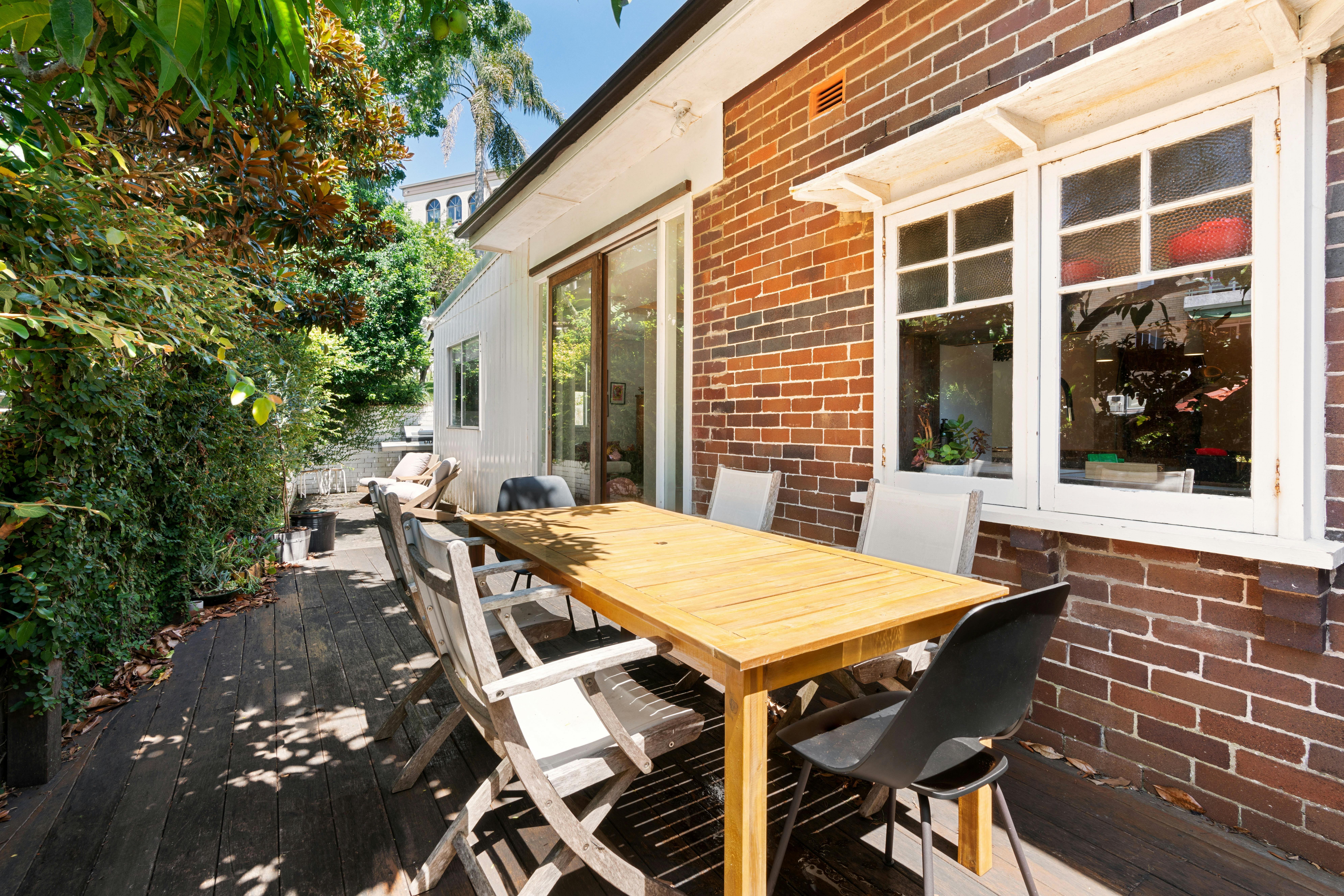 鬱鬱蔥蔥的花園內設有帶木桌和椅子的戶外休息區。