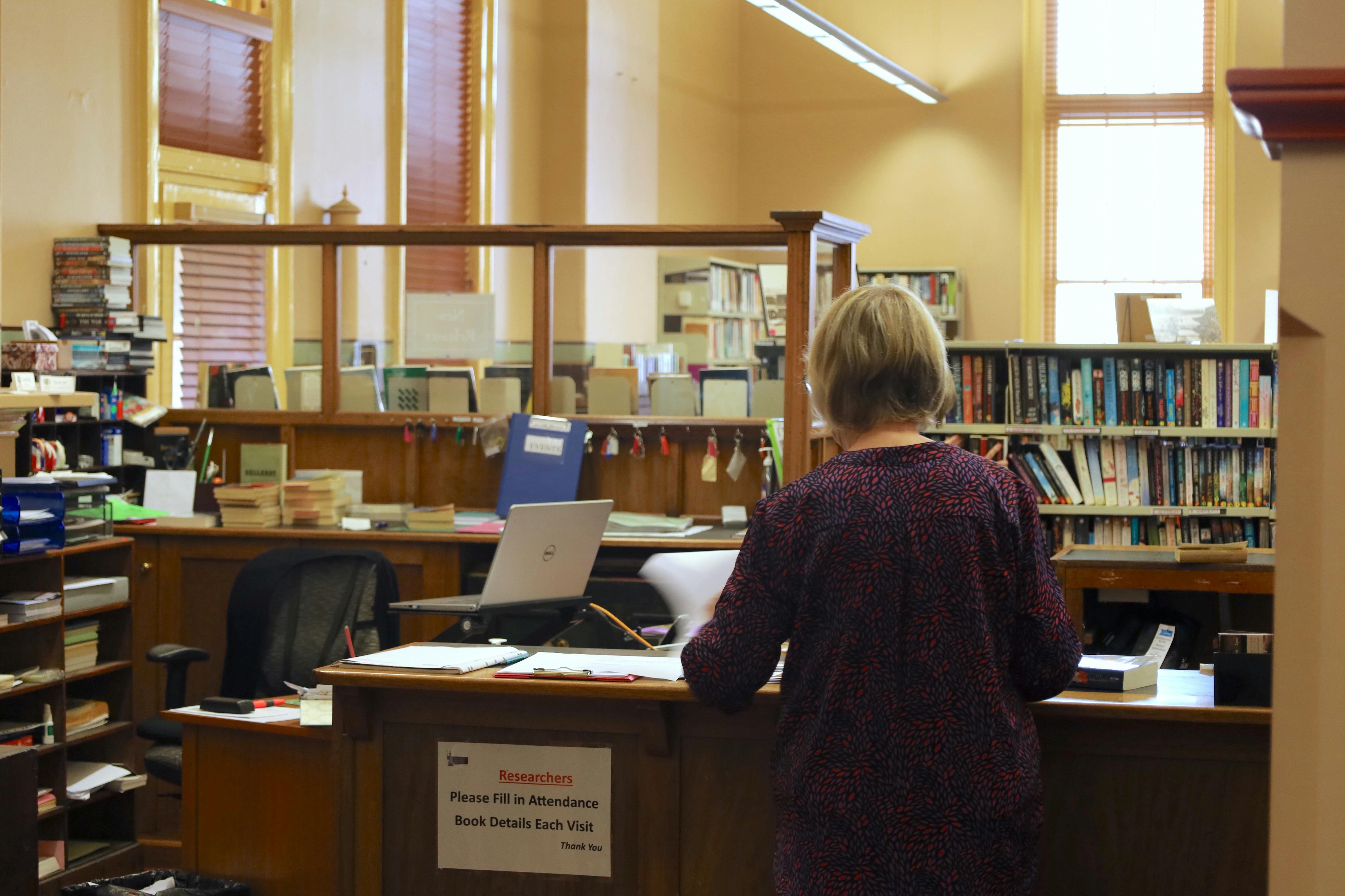 Photo of librarian working behind a desk