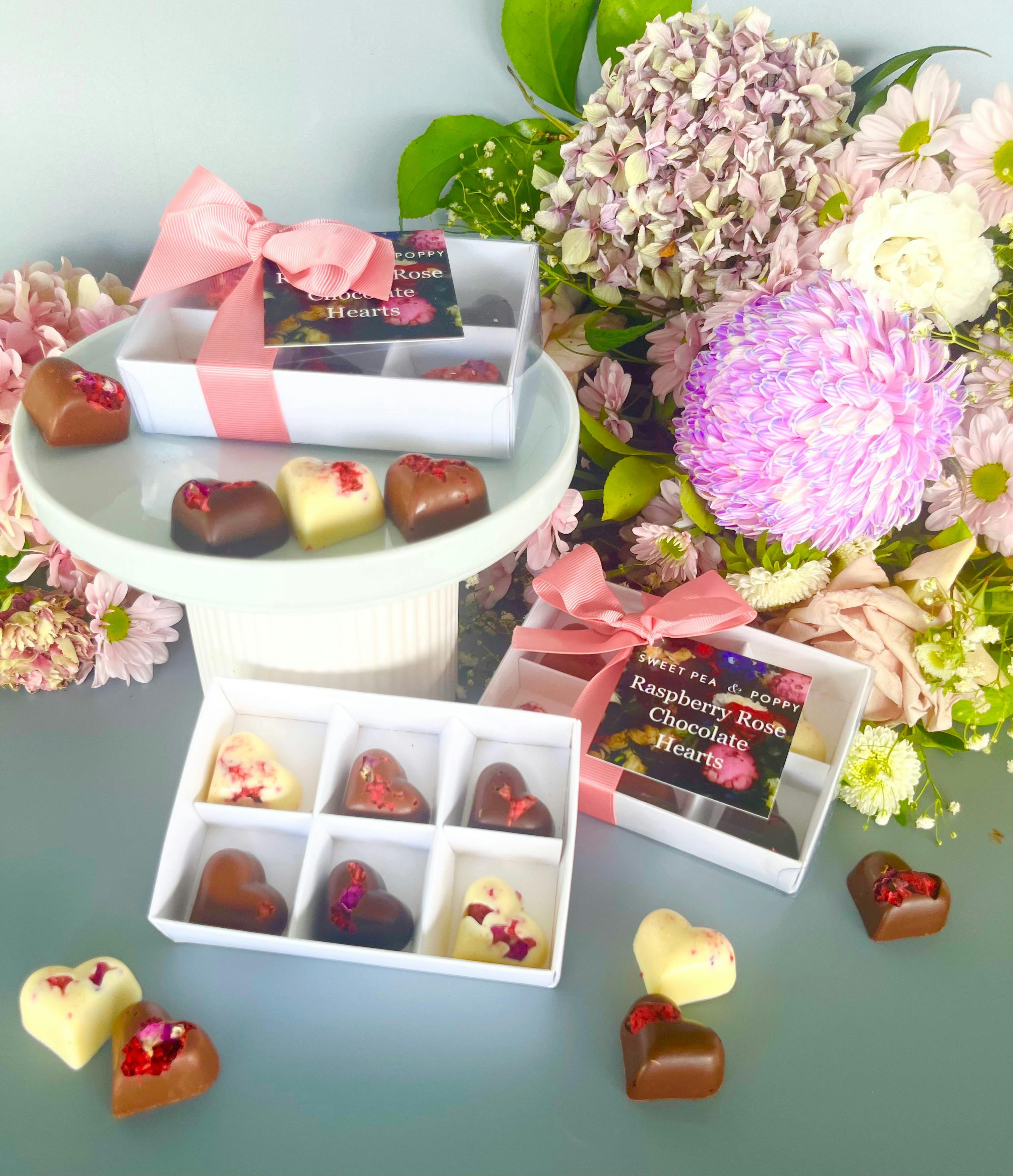gift boxed artisan chocolate hearts With individual artisan chocolate hearts, flowers in backhround