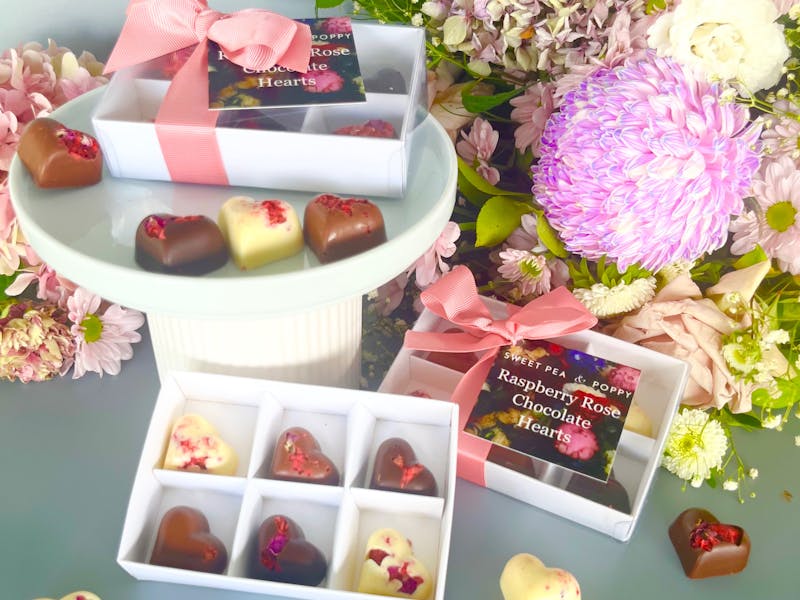 gift boxed artisan chocolate hearts With individual artisan chocolate hearts, flowers in backhround