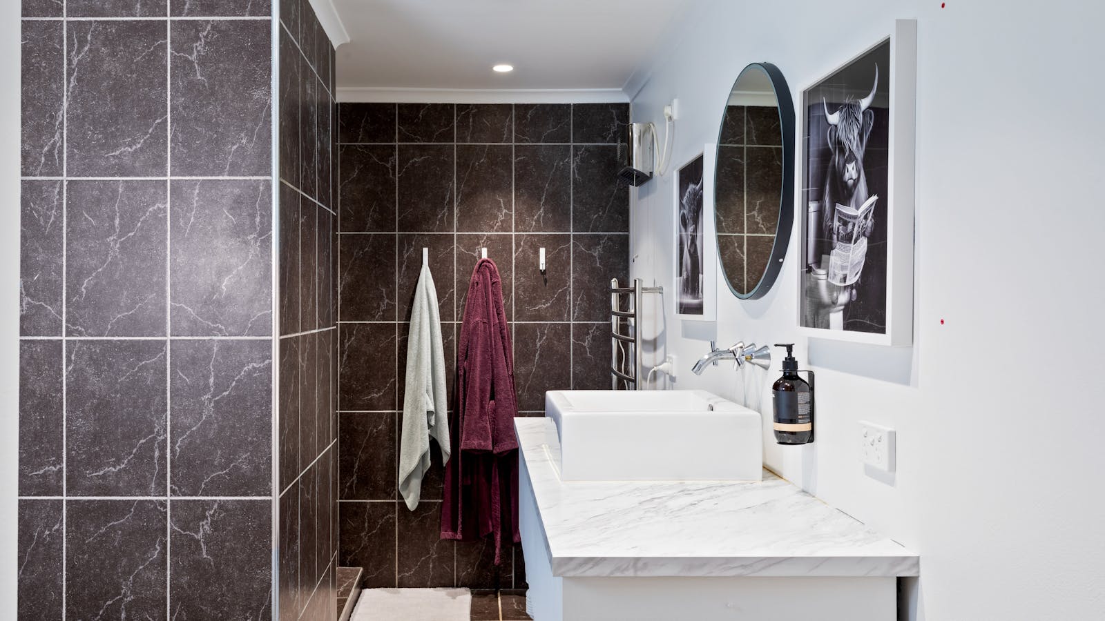Modern bathroom with washer, dryer, and heated towel rack