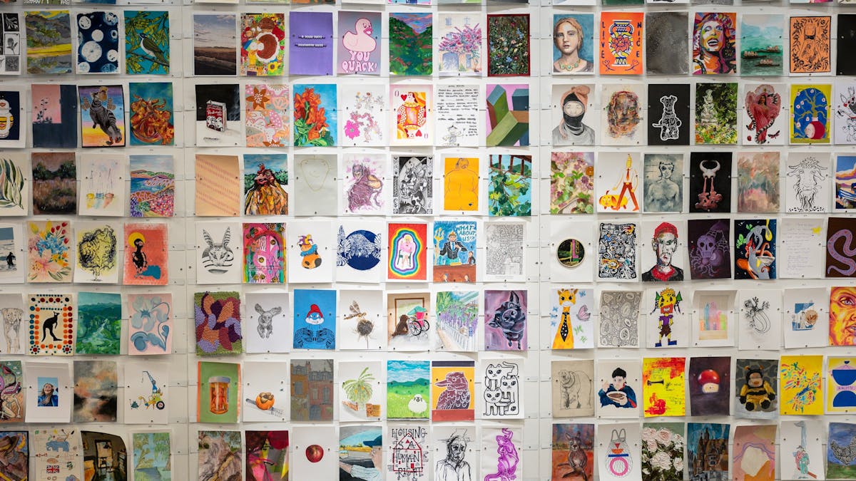 A5 artworks in portrait orientation displayed on a white wall at the Incognito Art Show.