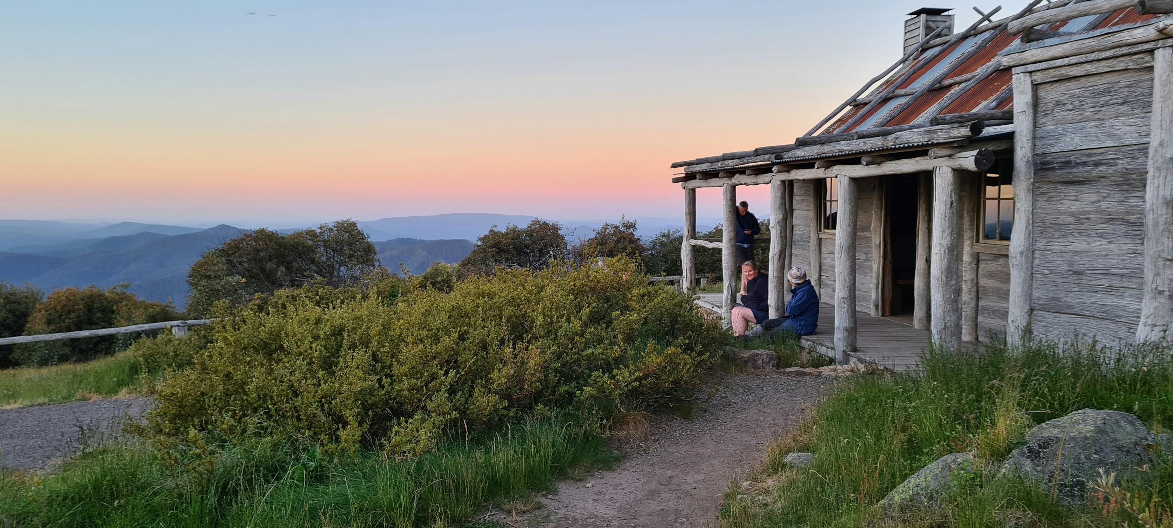 Hikers watching sunset from Craig's Hut porch.