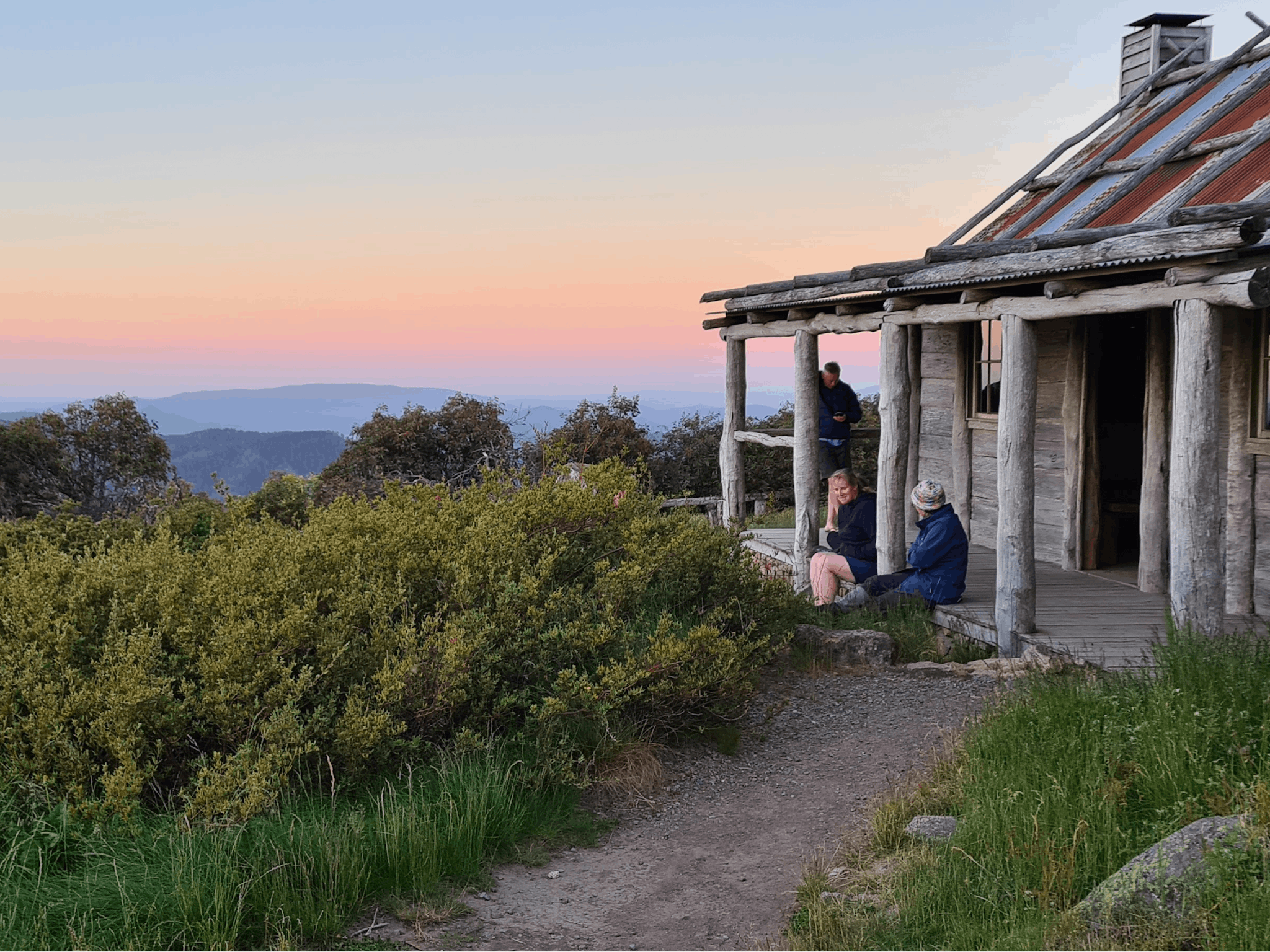 Hikers watching sunset from Craig's Hut porch.