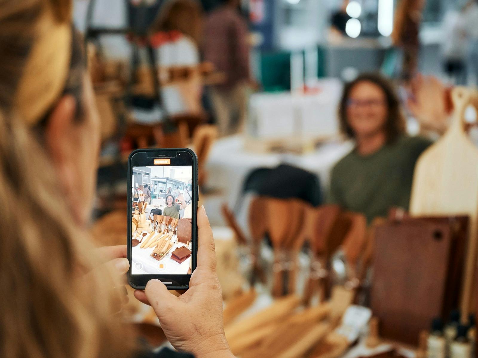A customer is captured photographing one of the stallholders at a recent Sydney Artisans Market