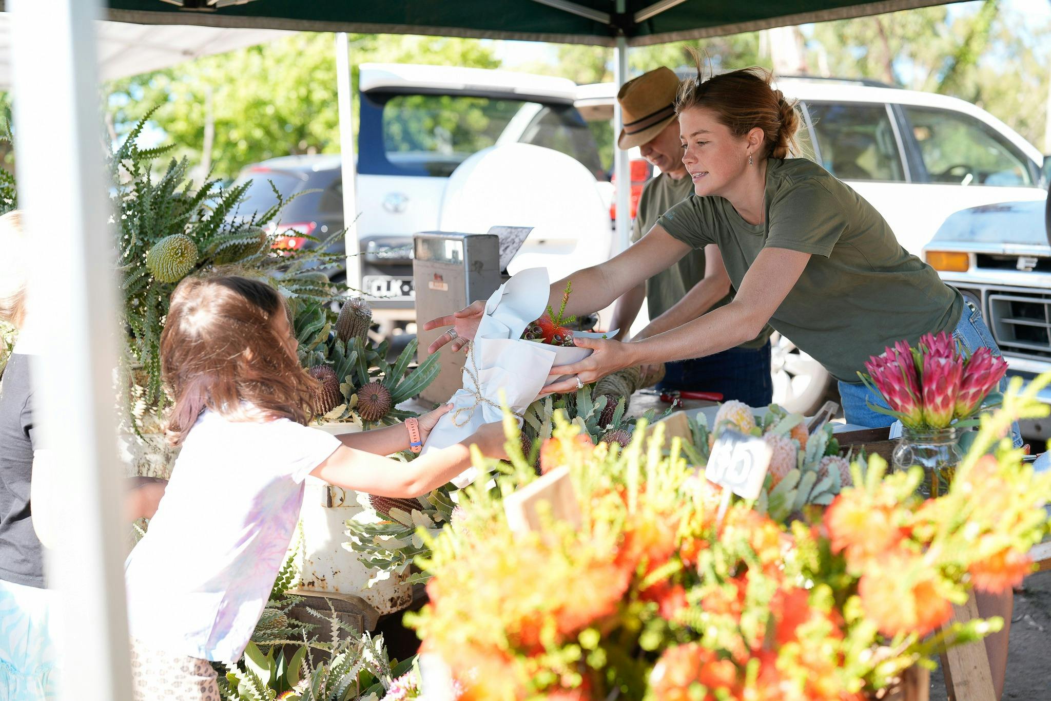 Shoppers buying fresh flowers at the Peninsula Wildflower stall on a beautiful market day