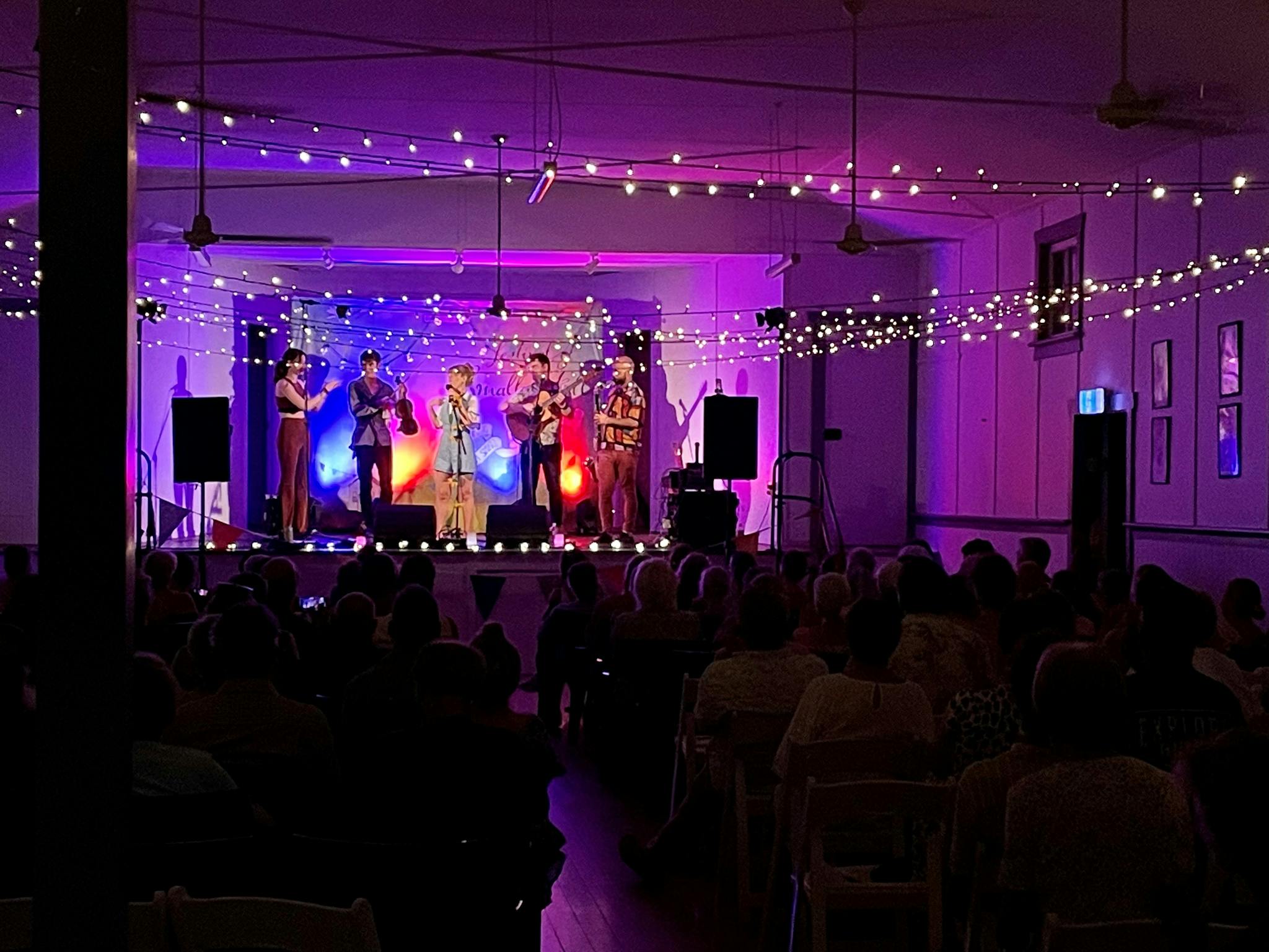 Singers on stage with purple light