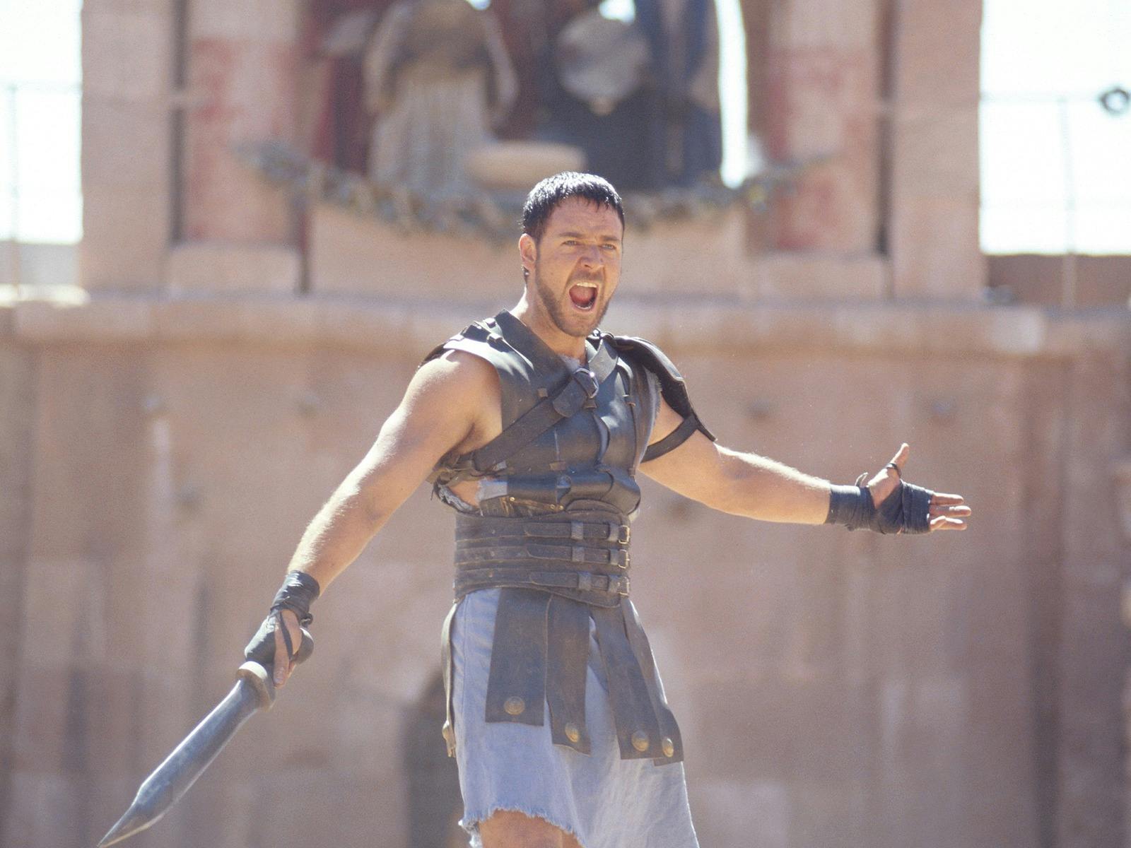 Russell Crowe's character in Gladiator holds a sword wearing medieval clothing preparing to fight Russell Crowe's character in Gladiator holds a sword wearing medieval clothing preparing to fight