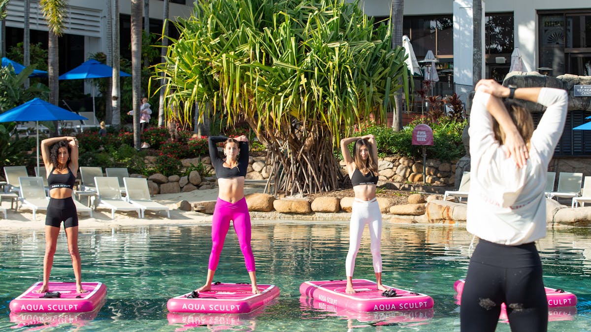 Participants standing on the boards doing arm stretches