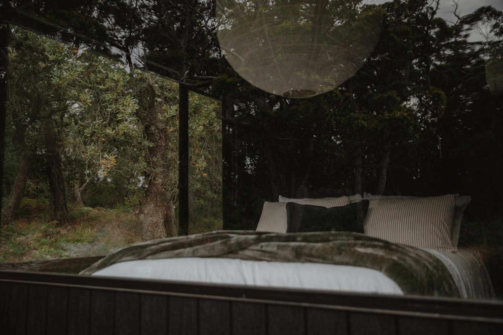Looking at a bed through a large window