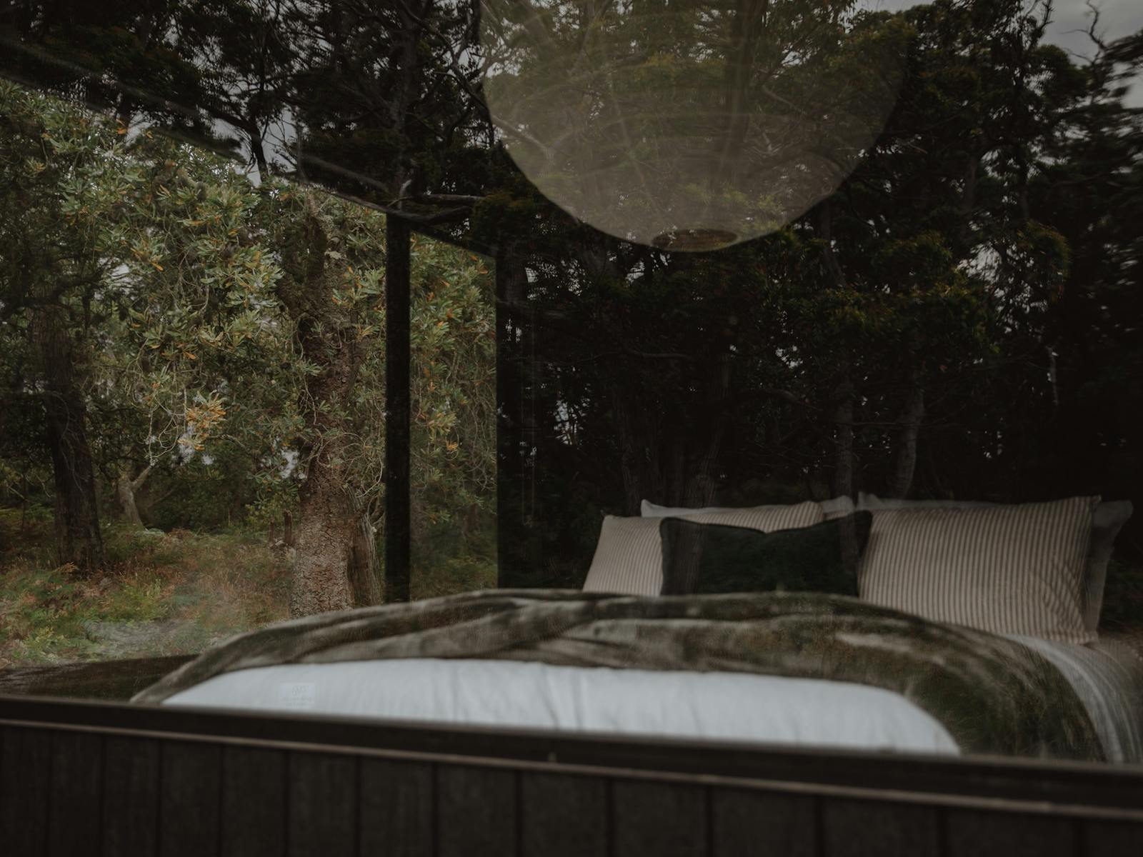 Looking at a bed through a large window