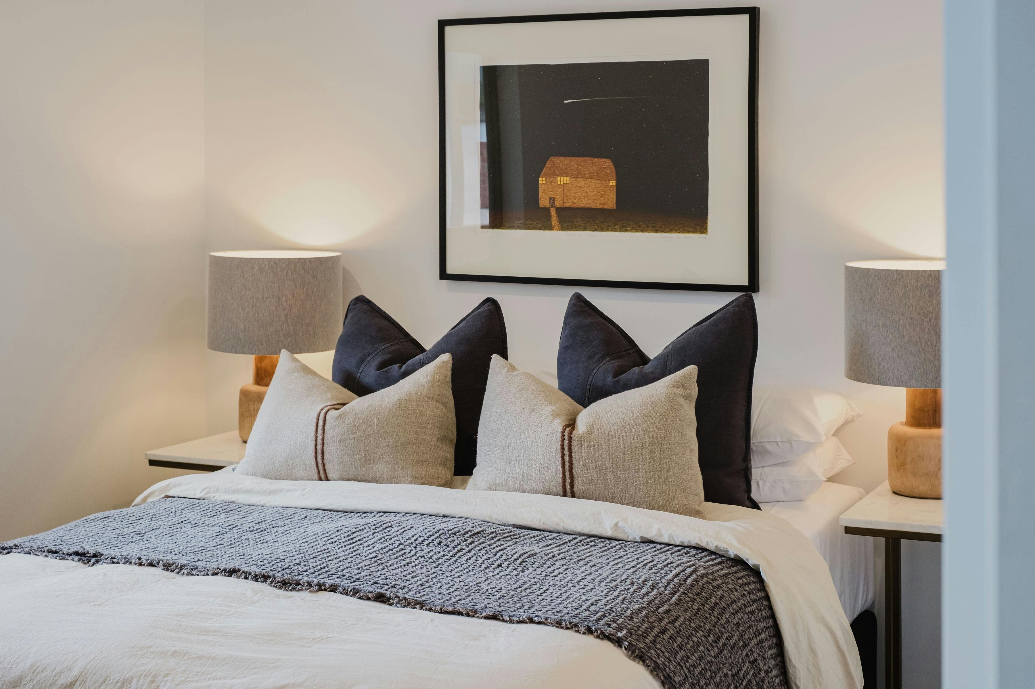 Hester arthouse townhouse bedroom with table side lamp and painting hanging on the wall