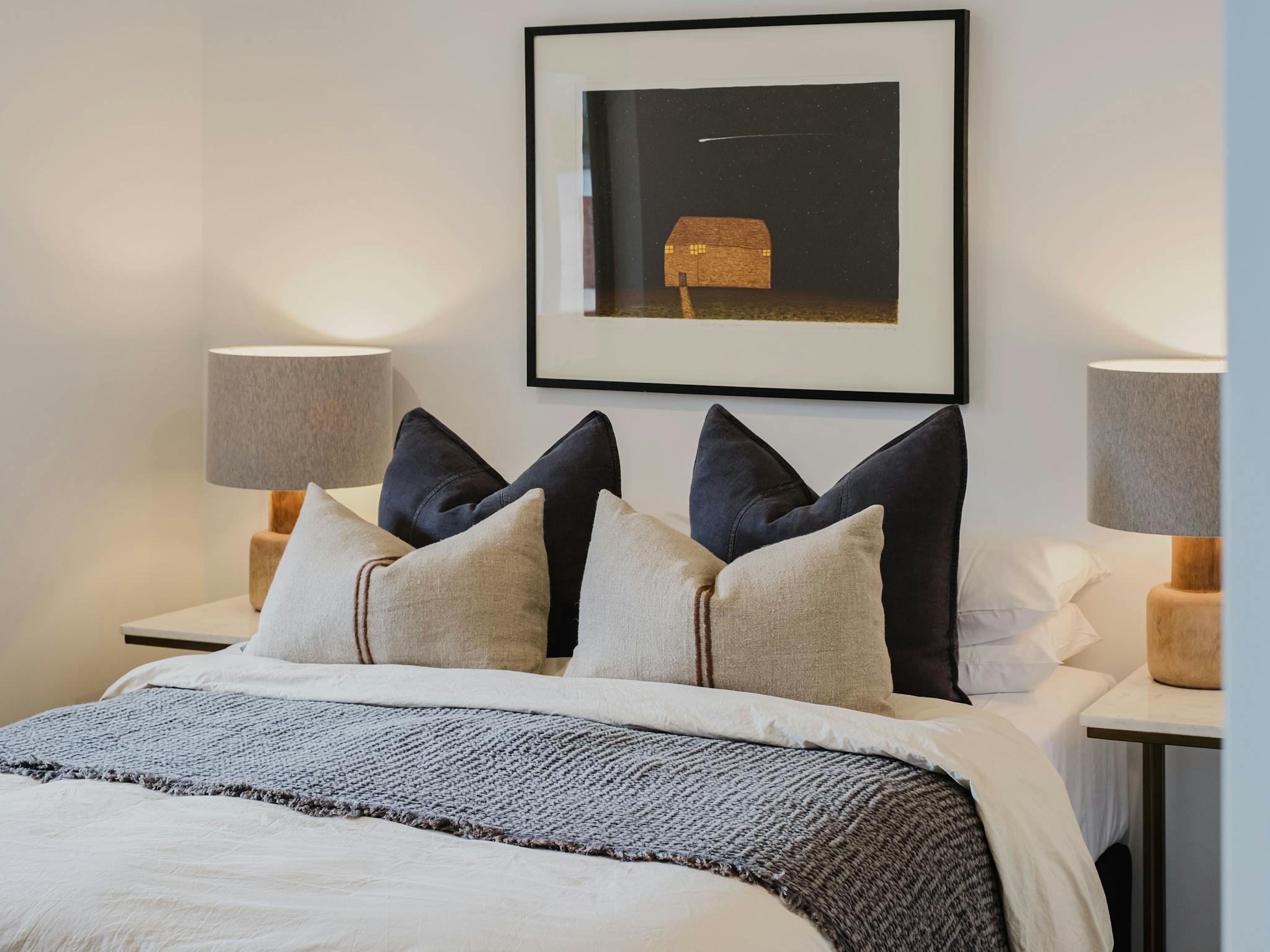 Hester arthouse townhouse bedroom with table side lamp and painting hanging on the wall