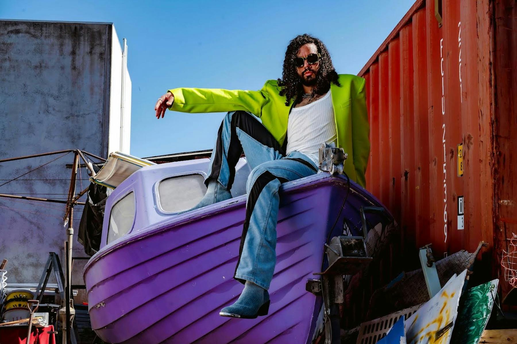 Queency sits atop a purple boat