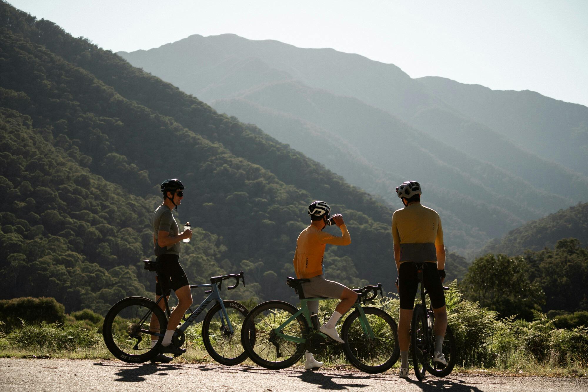 Three cyclists taking a break with the mountain views on the Falls Creek 7 Peaks Challenge route