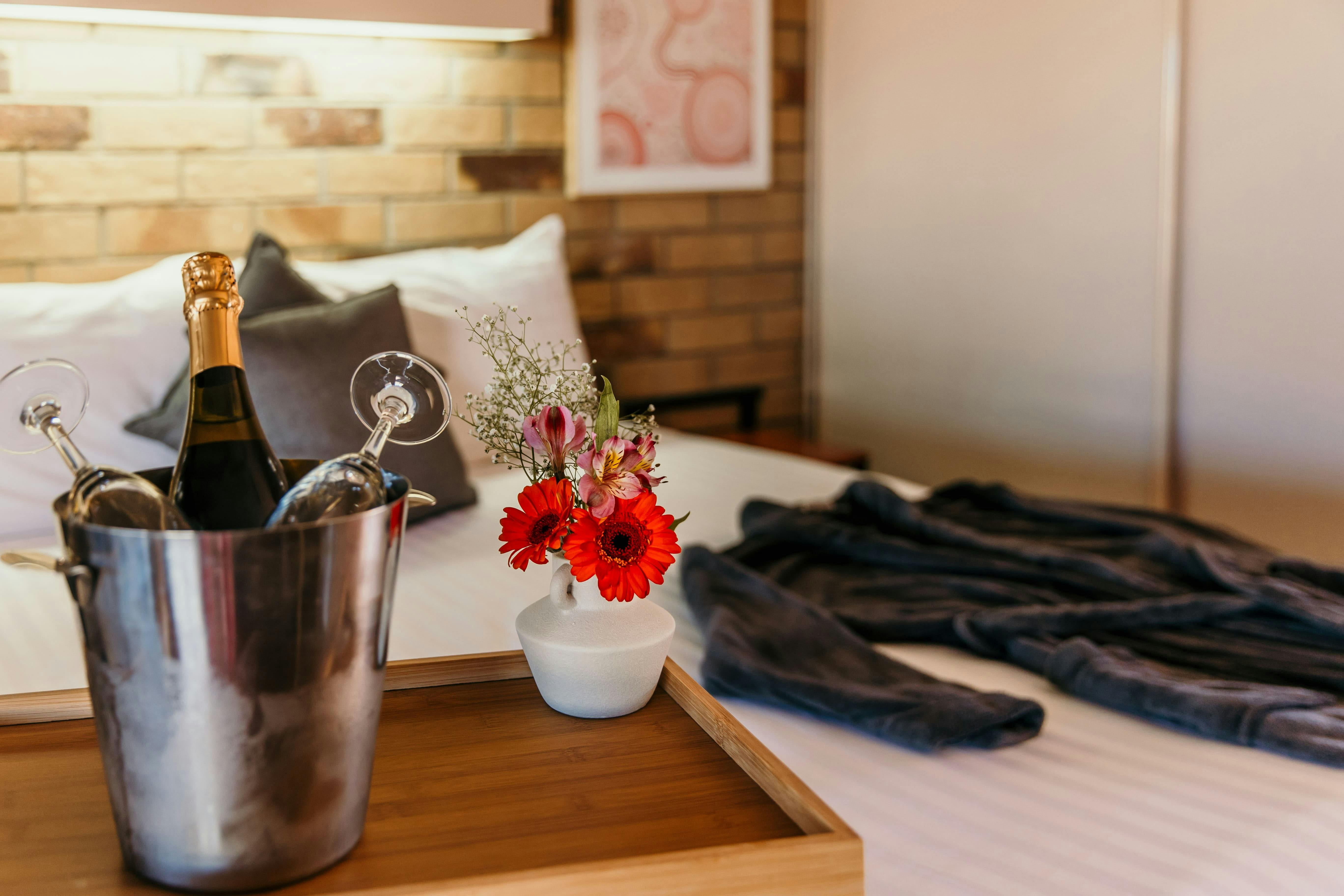 King bed with a robe, cheese platter and champagne ice bucket.