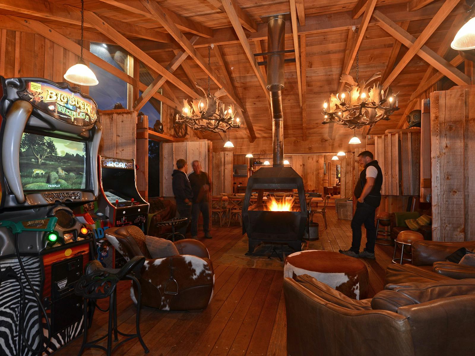 Bruny Island Lodge main fireplace evening with arcade games and couches