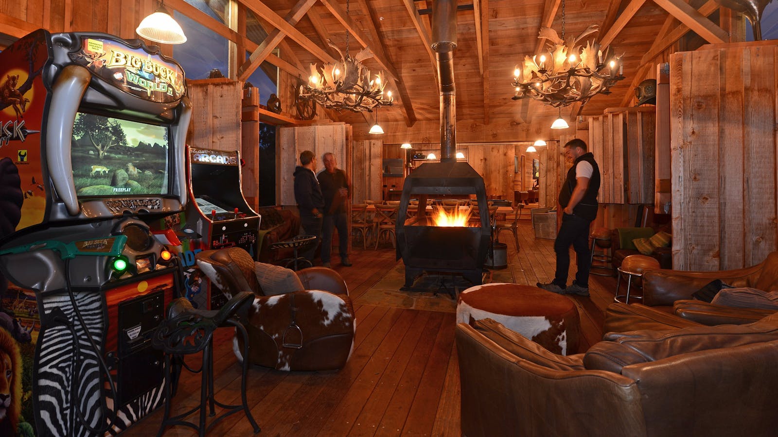Bruny Island Lodge main fireplace evening with arcade games and couches