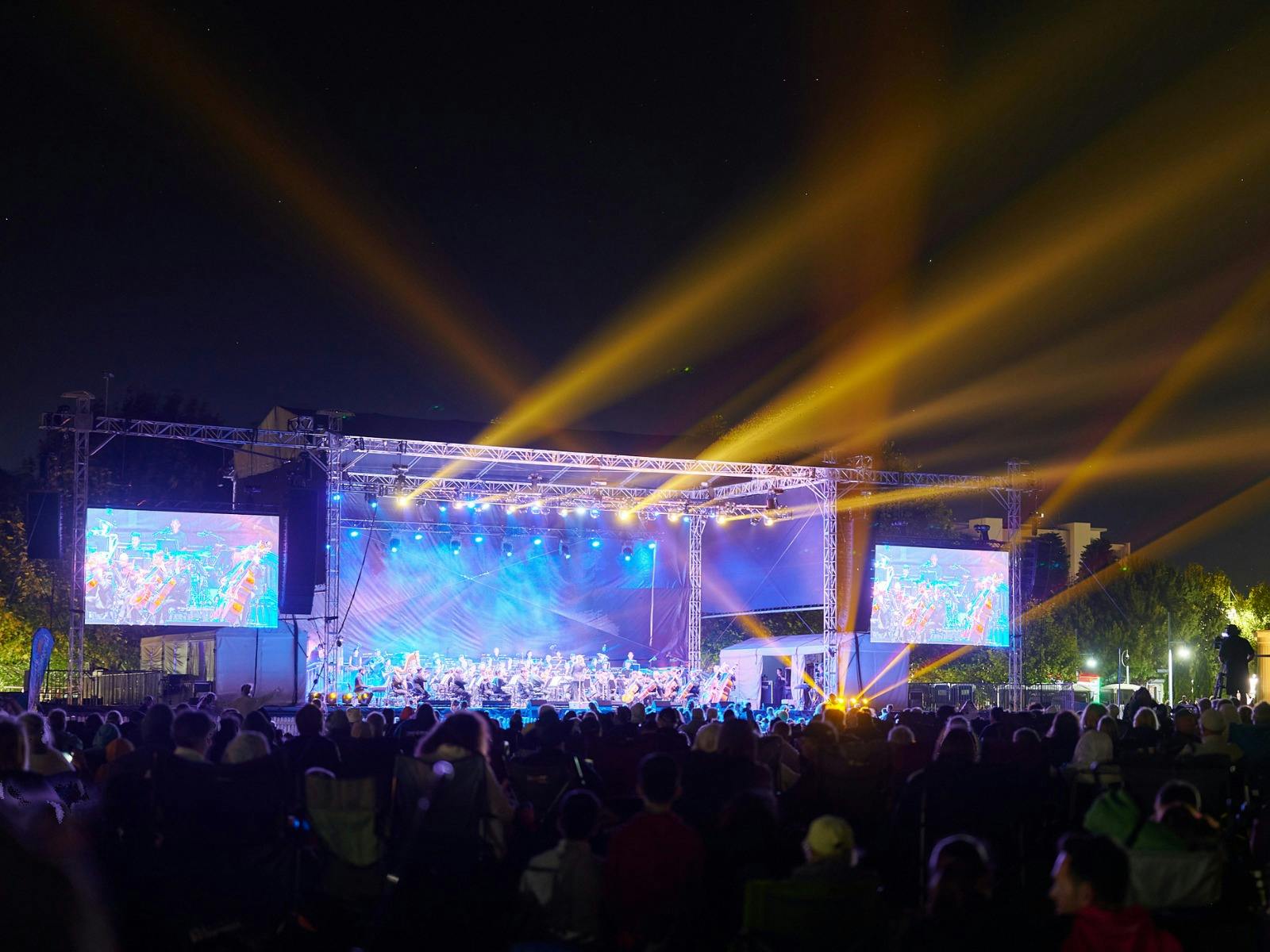 View of the stage at night lit up to show the orchestra playing