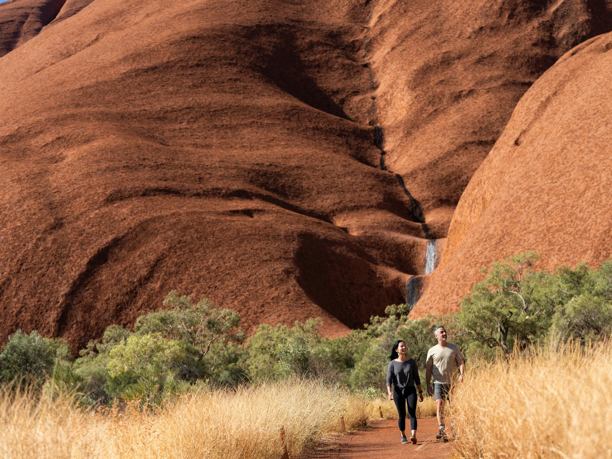 A couple walking at Uluru.