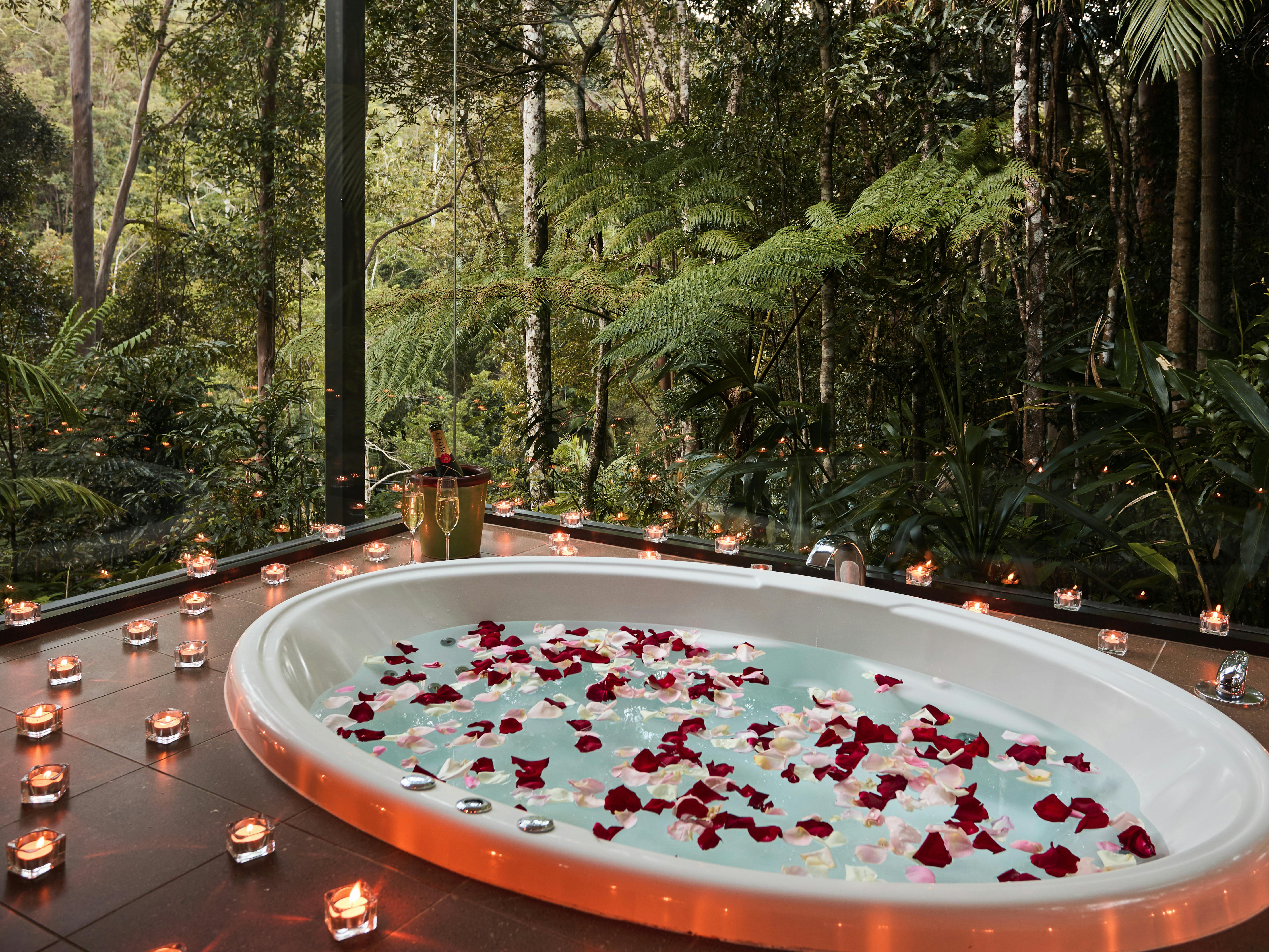 캔들 장미 꽃잎 샴페인이 있는 로맨틱한 스파 욕조