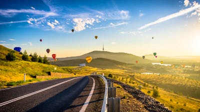 road framed by balloons on horizon