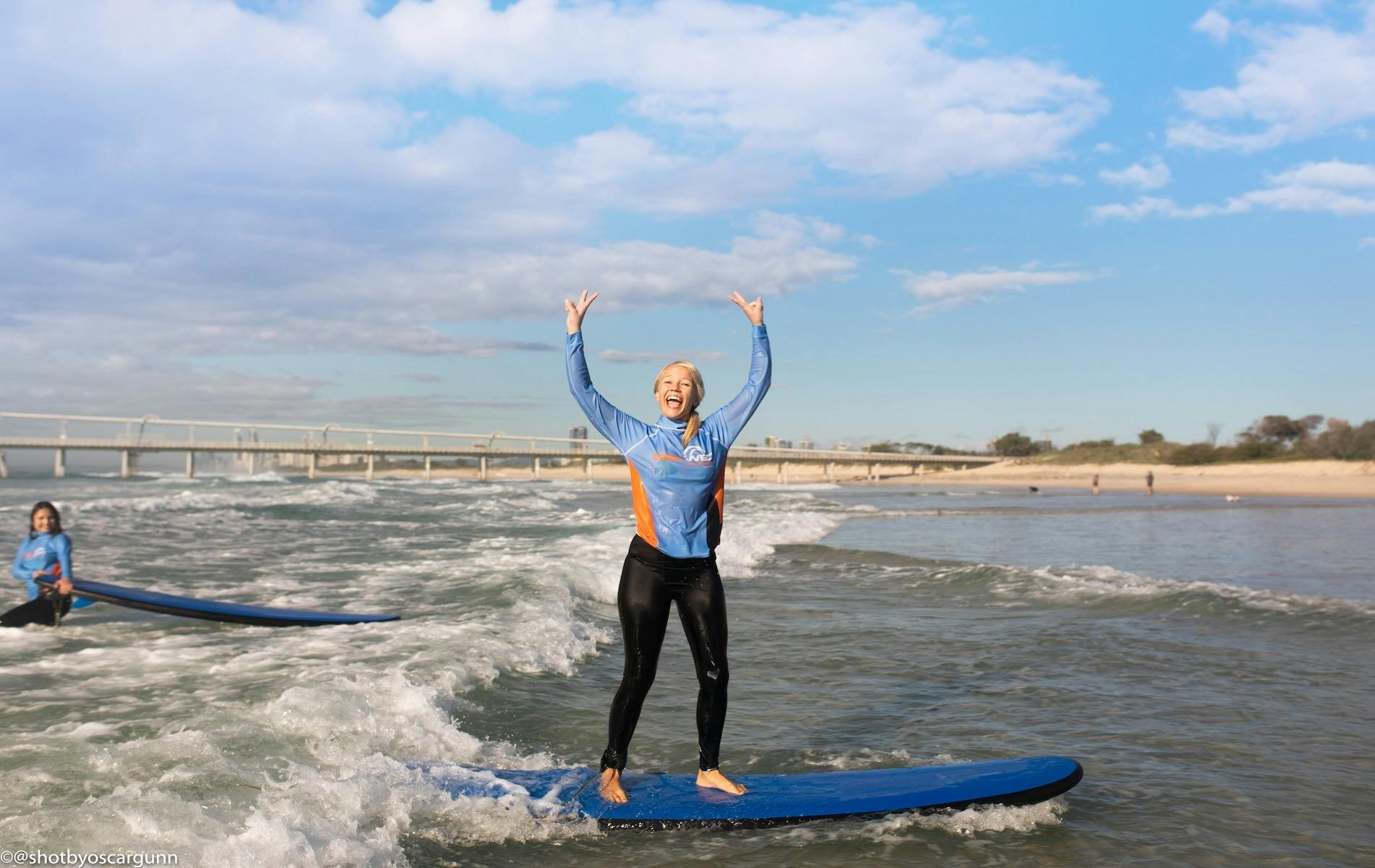 A stoked student standing up on her first wave!