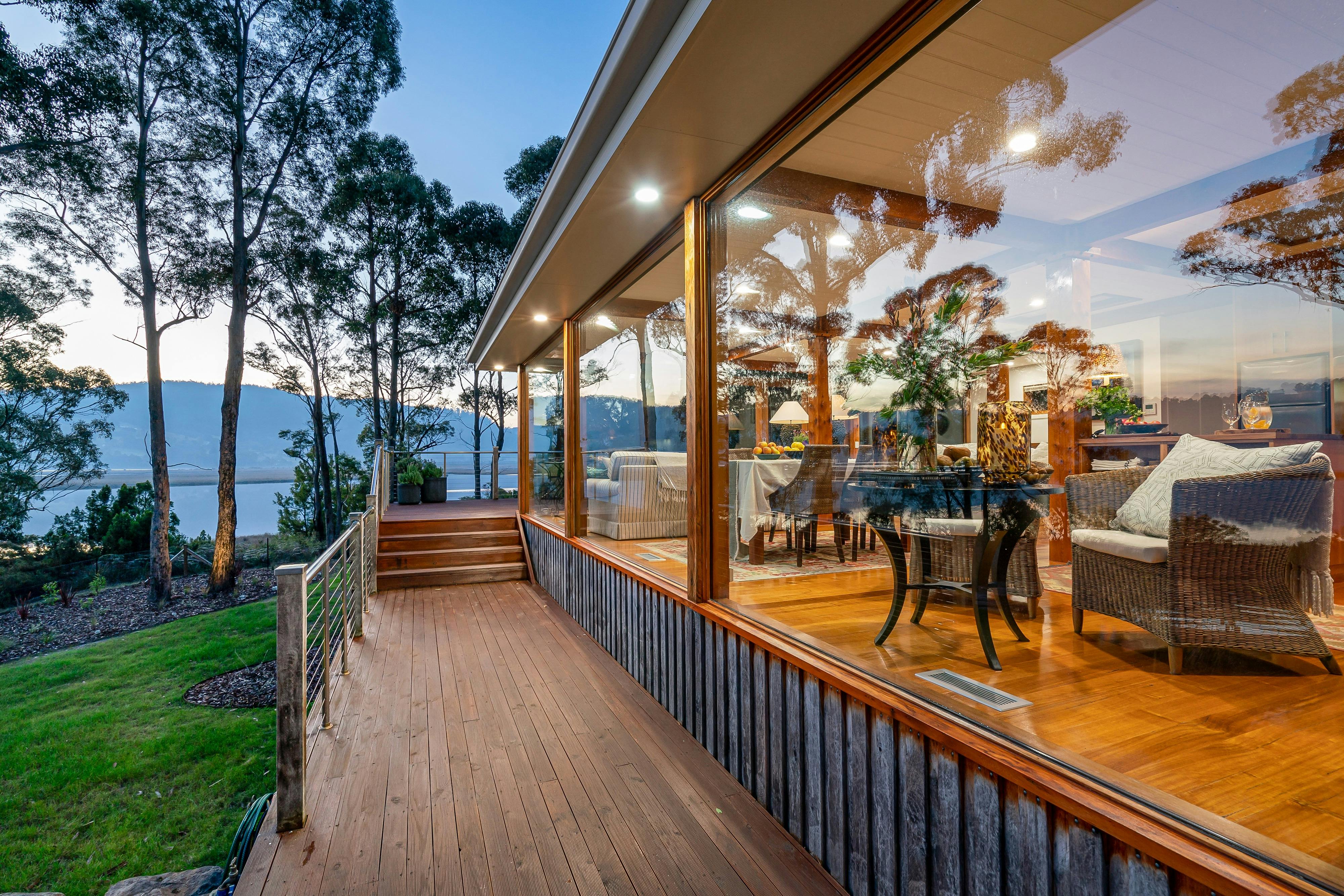 The exterior of deck of the Huon River Hideaway showing the floor to ceiling windows along one side