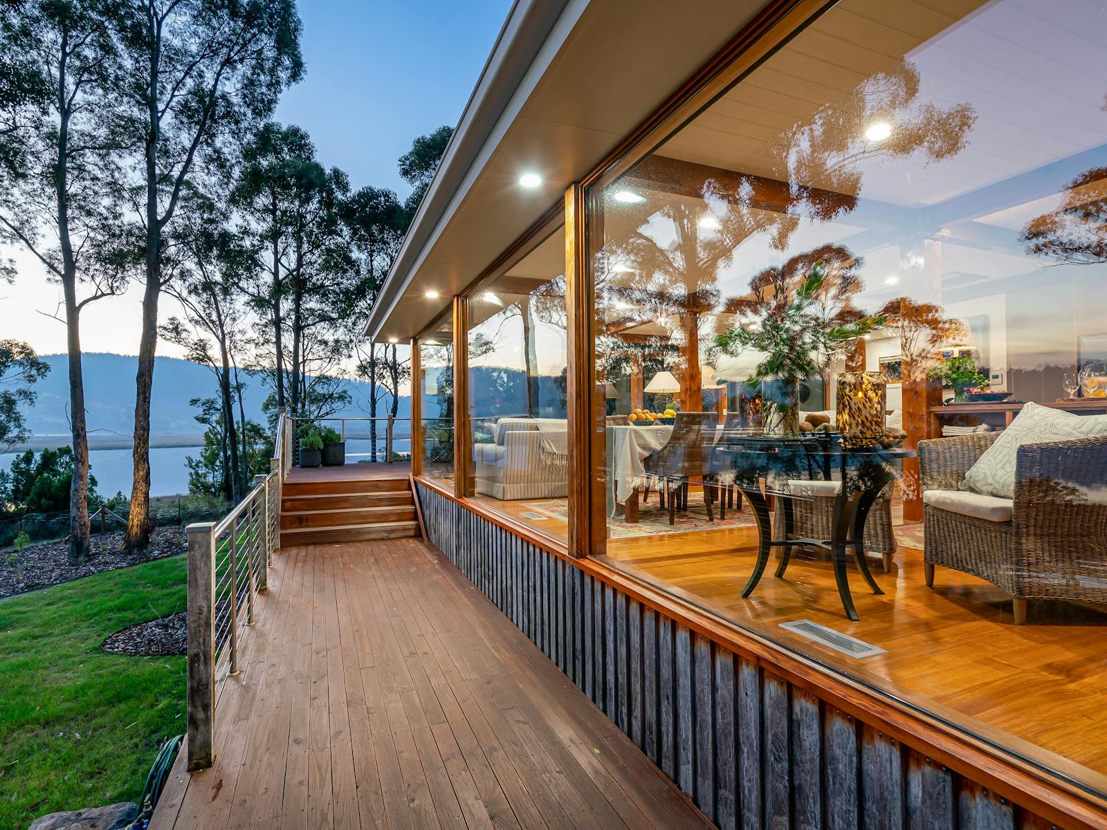 The exterior of deck of the Huon River Hideaway showing the floor to ceiling windows along one side