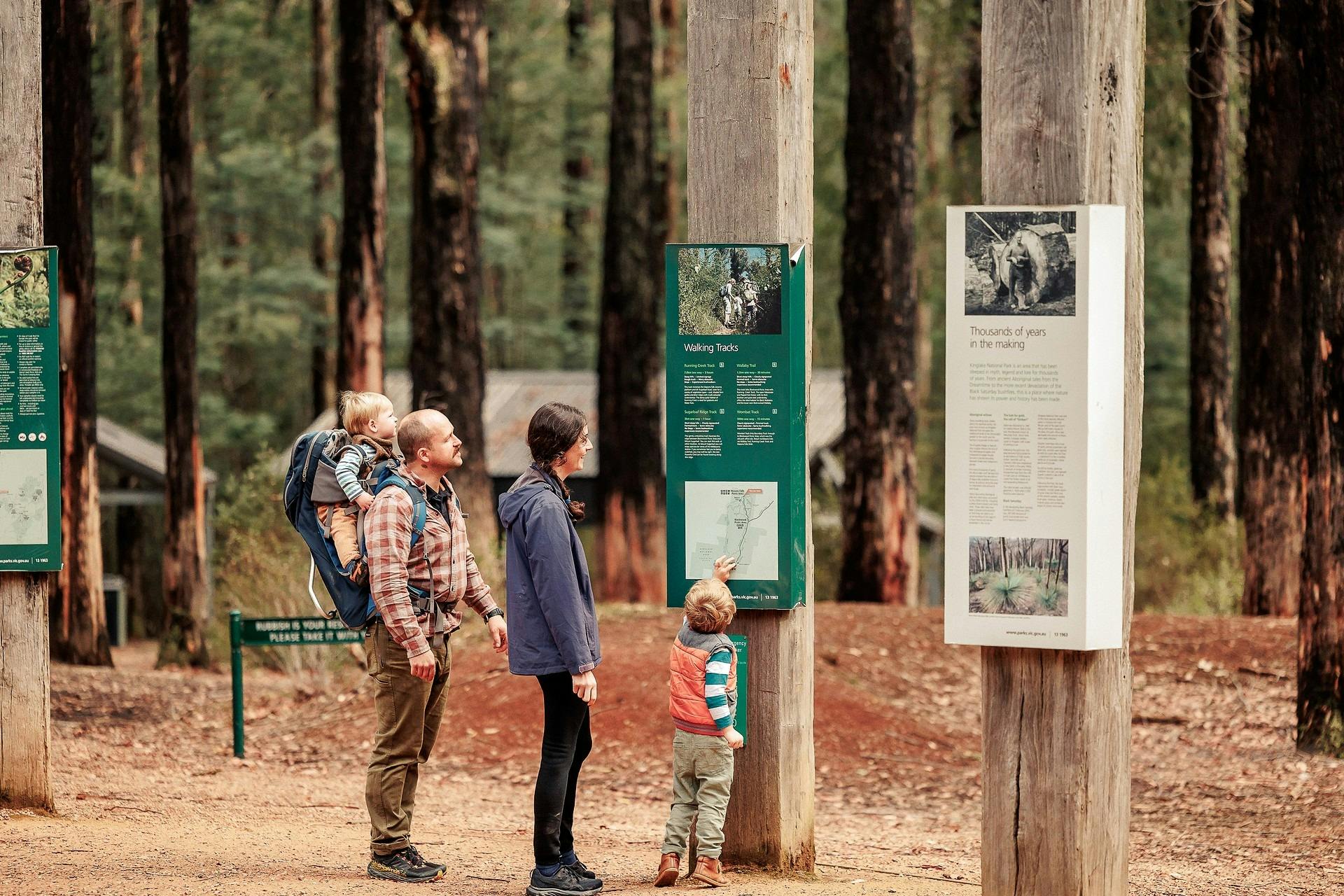 family of four reading the walking track information board at Masons Falls
