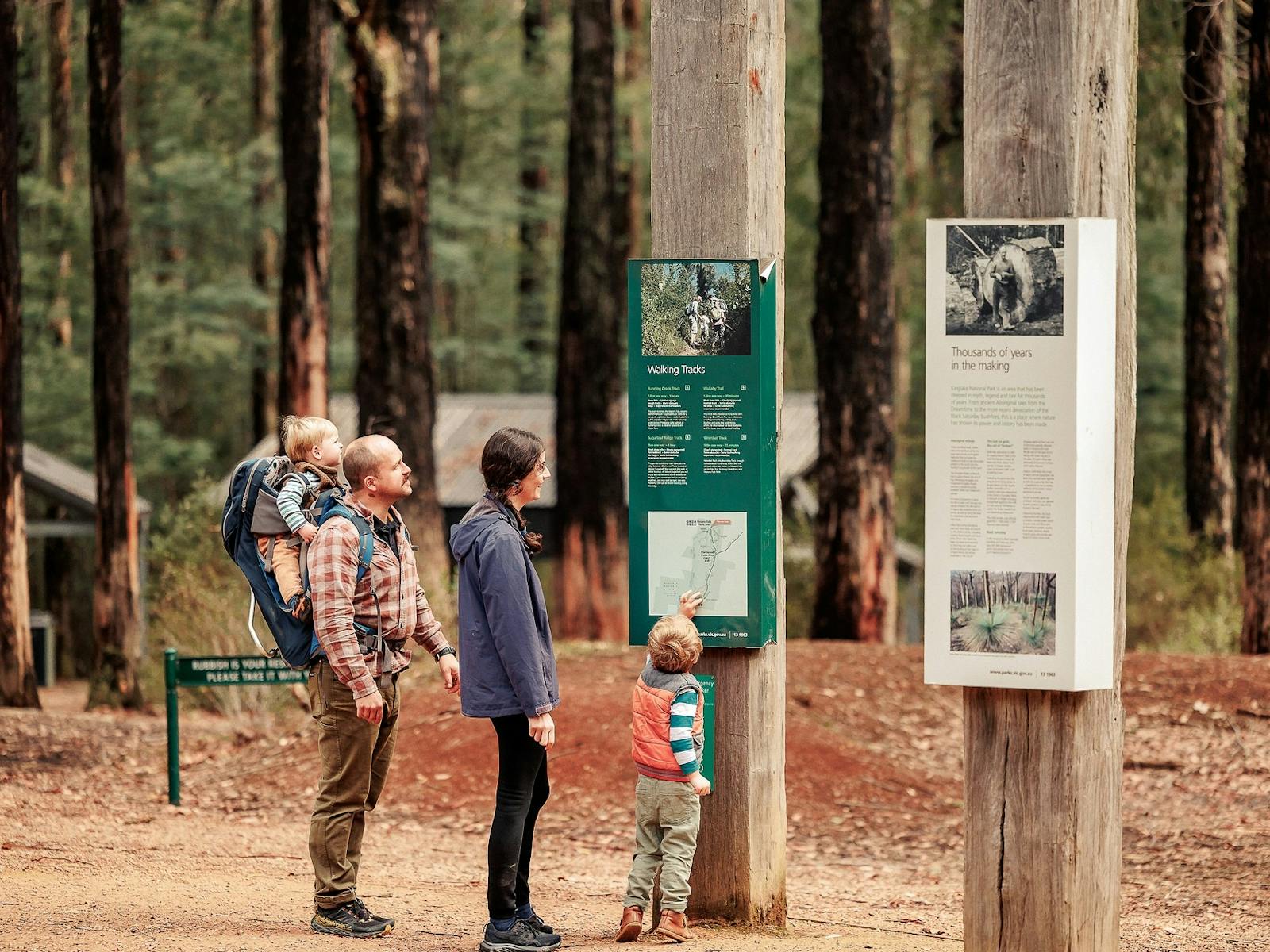 family of four reading the walking track information board at Masons Falls