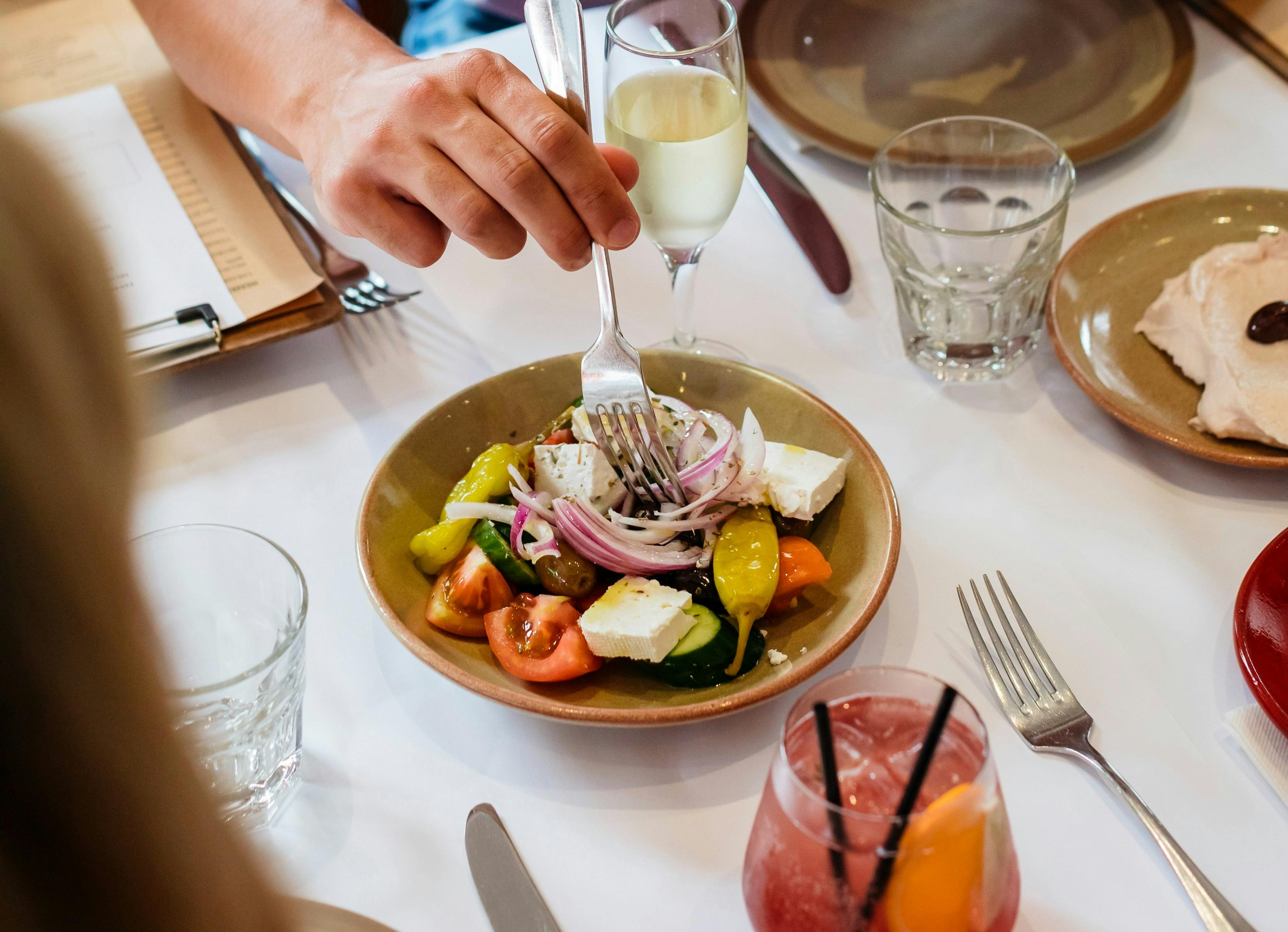 Menschen genießen klassisches griechisches Essen, erhältlich bei Kouzina Greco in Parramatta