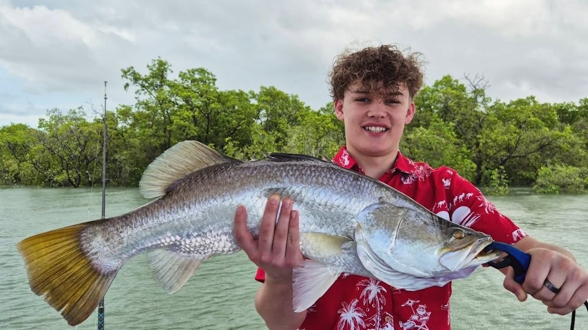 Man holding a barramundi caught with Gone Fishing Cairns in the inlet