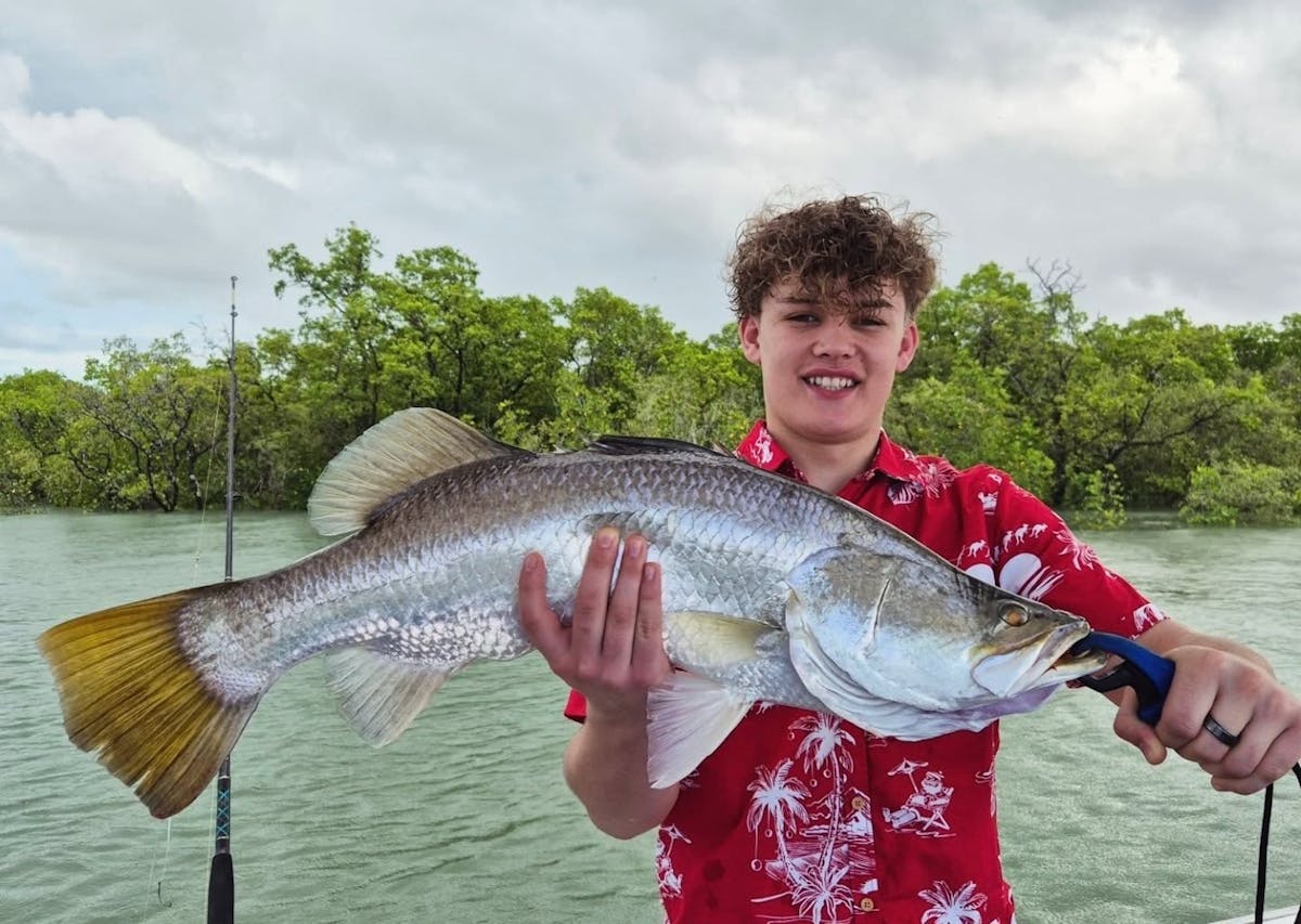 Man holding a barramundi caught with Gone Fishing Cairns in the inlet