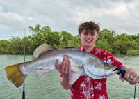 Man holding a barramundi caught with Gone Fishing Cairns in the inlet