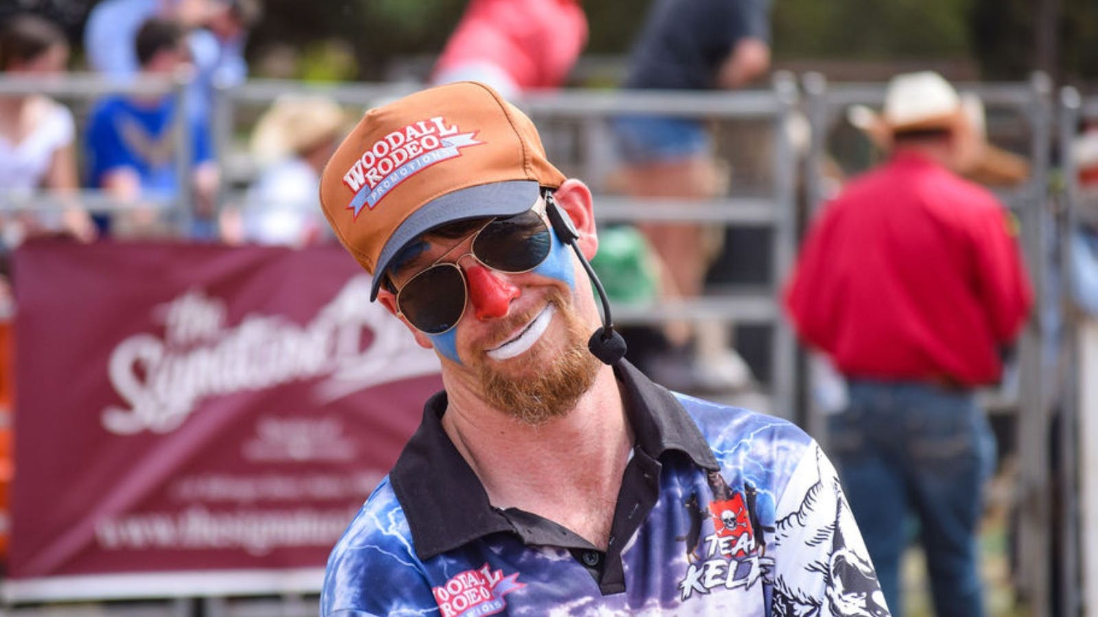 A rodeo clown smiles sarcastically at the camera
