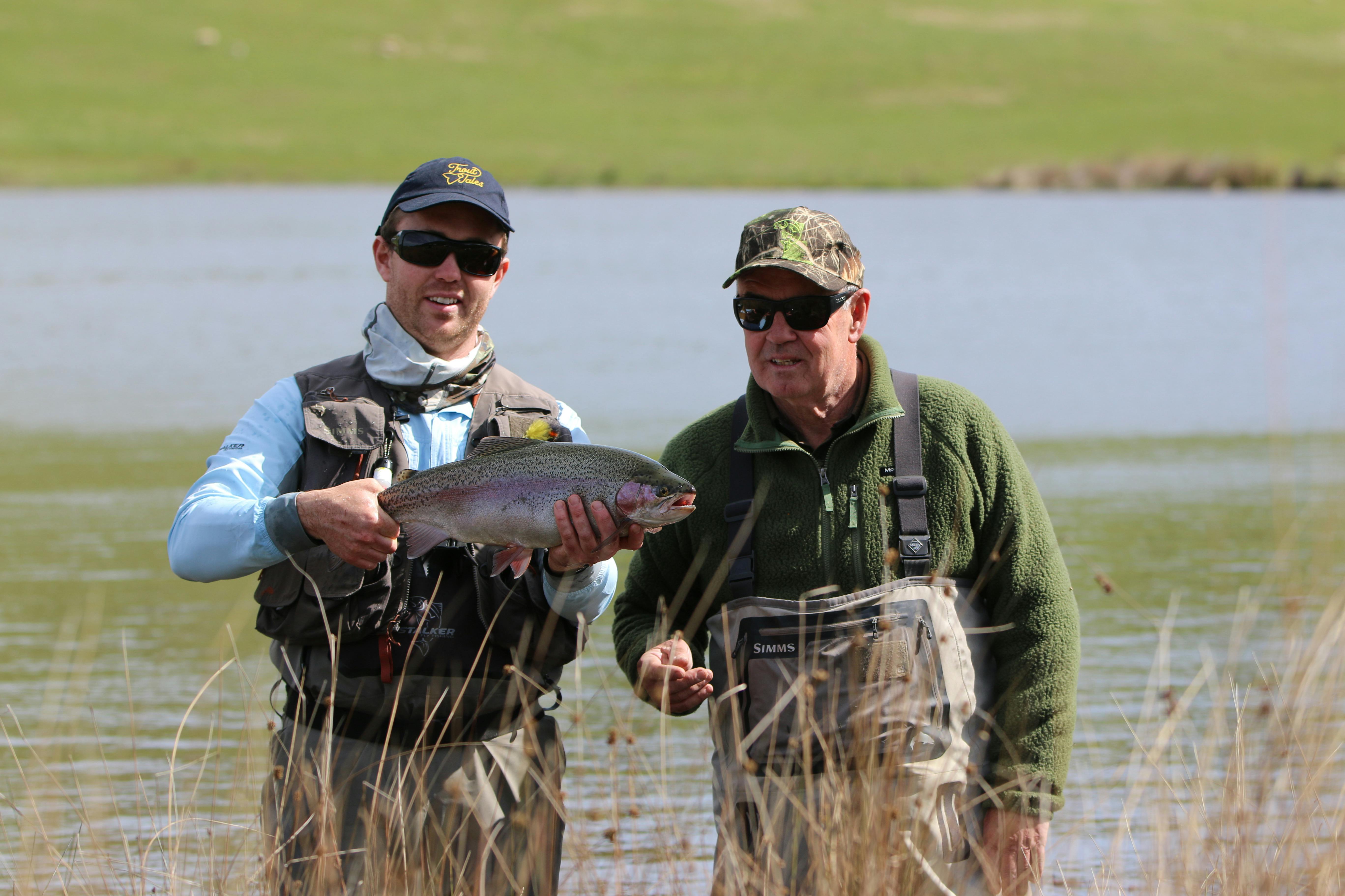 Two men holding large trout