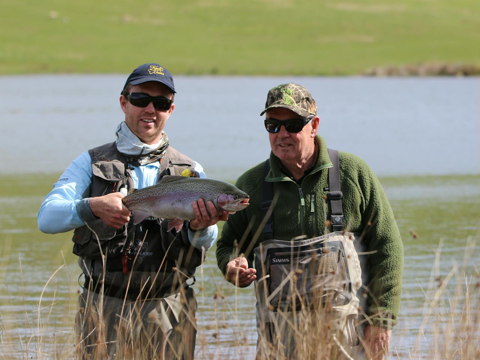 Two men holding large trout