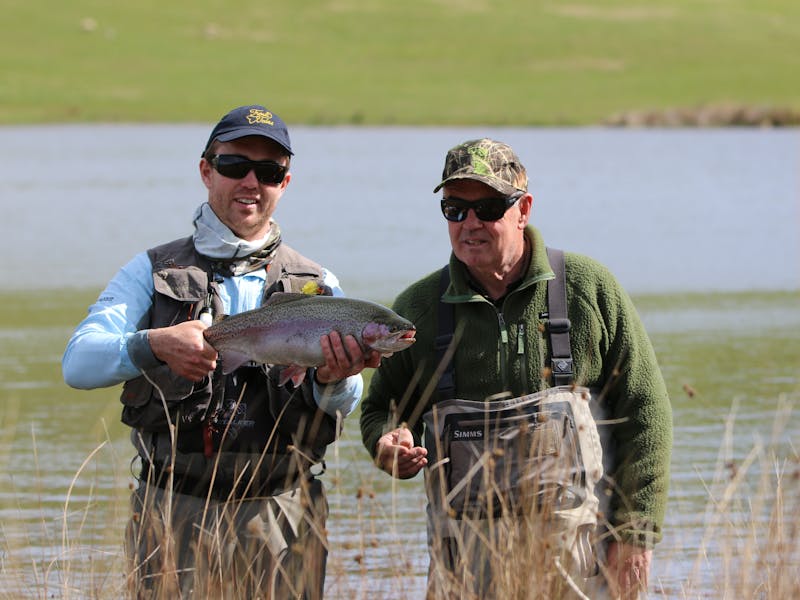 Two men holding large trout