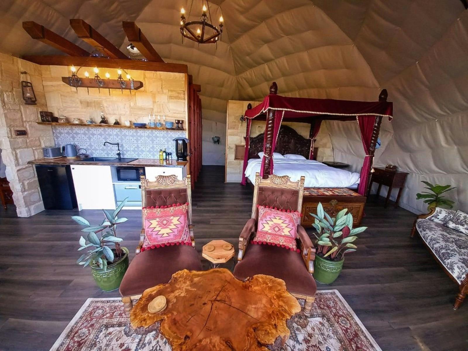 Interior of Serenity dome showing living space, king size four poster bed and kitchentte.