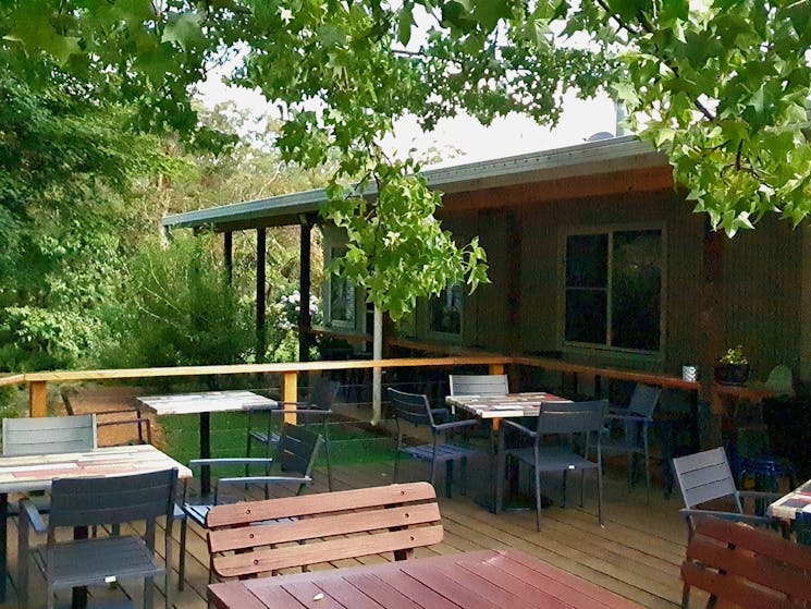 timber deck under cool trees for outdoor dining at The Drunken Trout Cafe