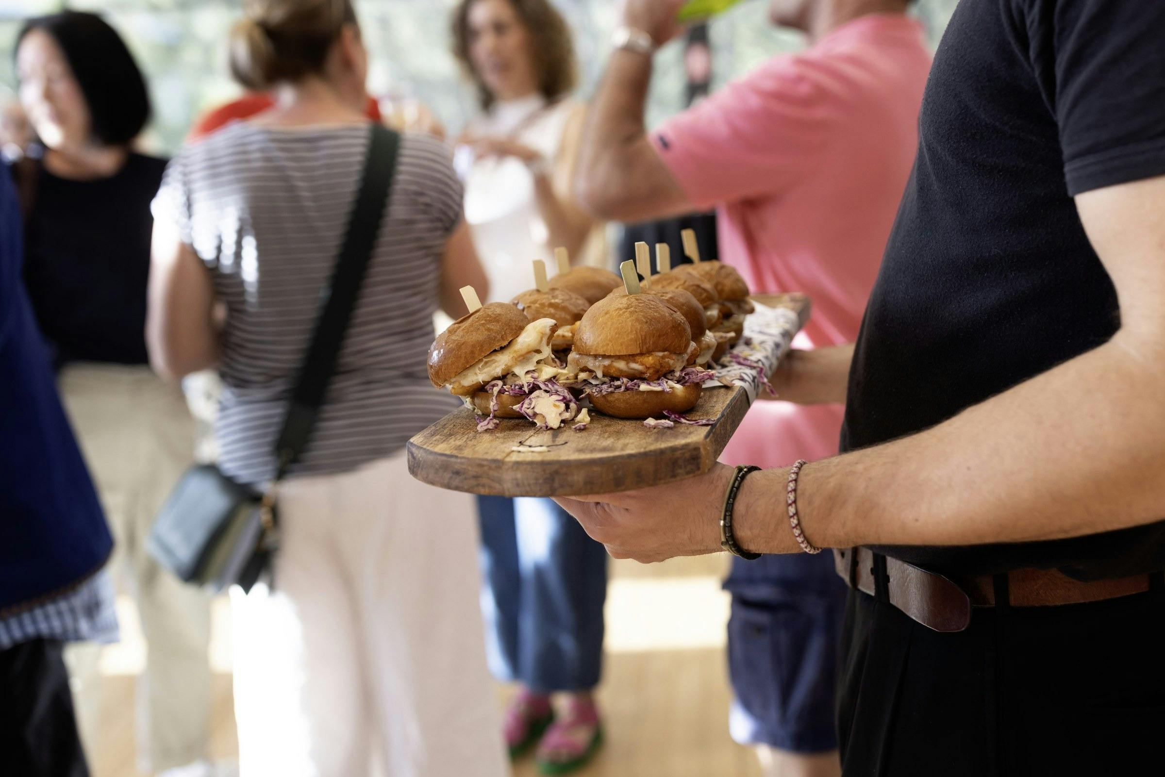 A plate of burgers being served to festival guests