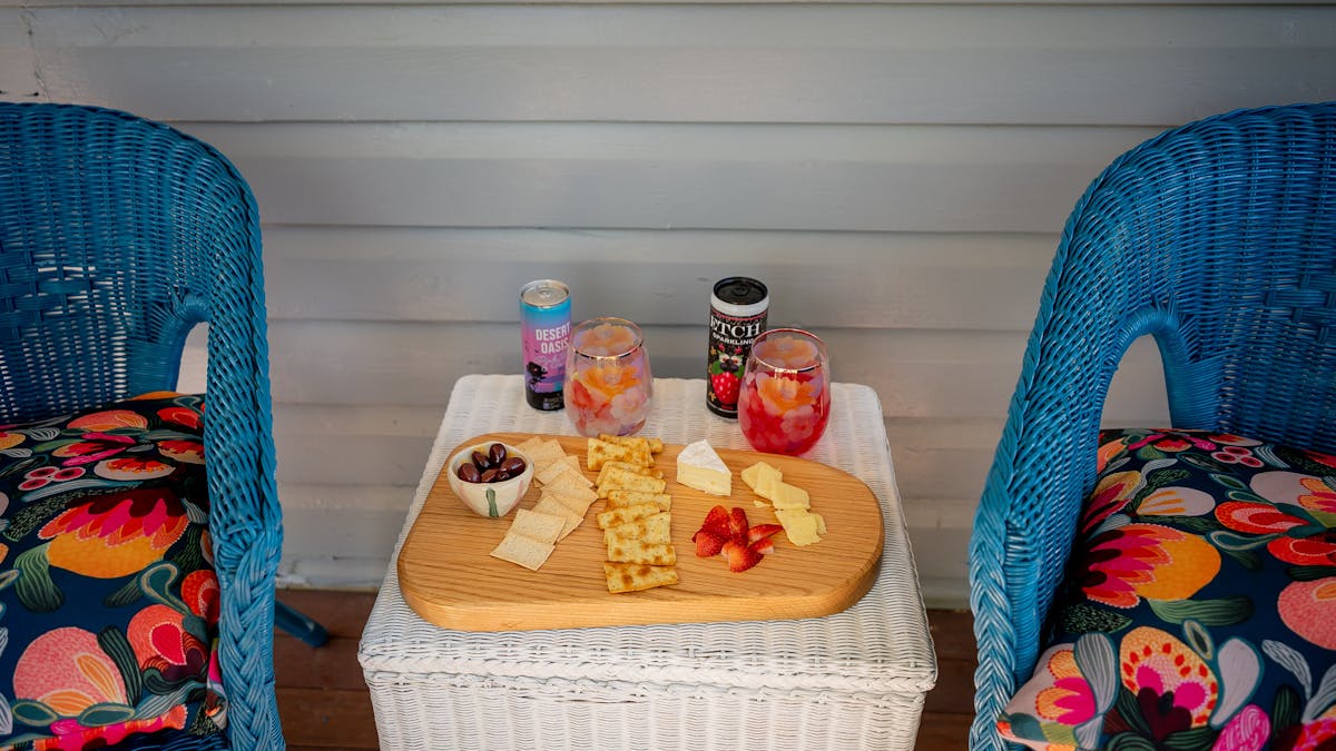 Cheese , biscuits and drinks next to two chairs on the undercover deck