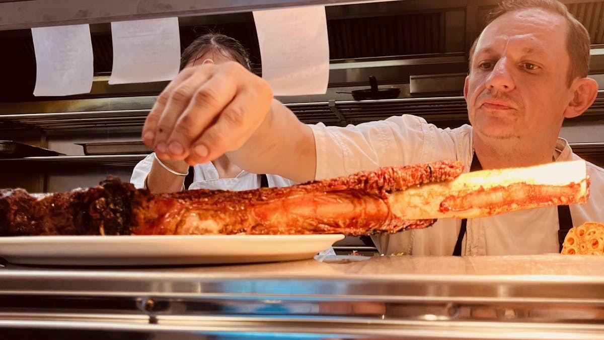 Photo of Club Whitsunday Chef seasoning a tomahawk steak