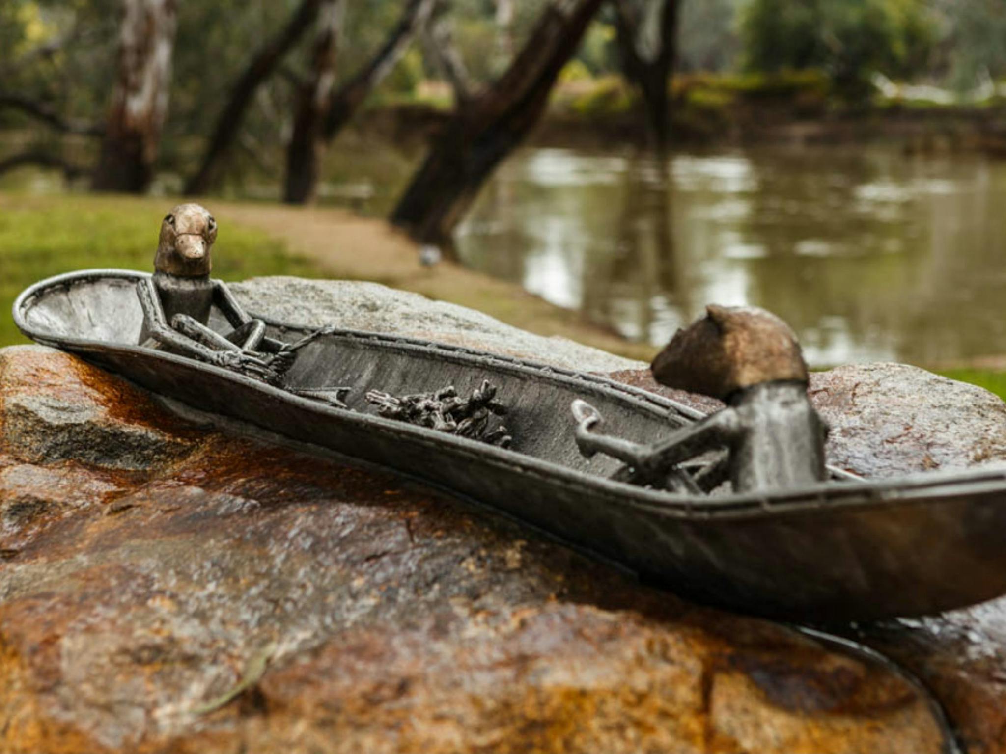 Canoe Sculpture showing the story of Mullinmurr - Playpus, ovens river, trees, river bank