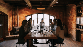 Guests sit around a large tasting table in Trott's Original Cellar Door.